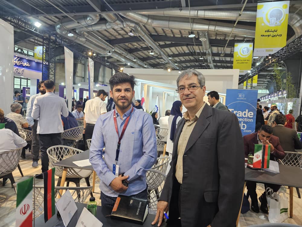 Afghan Circle Ltd. representatives at a trade exhibition with company signage.